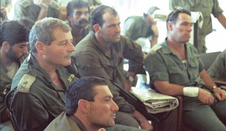 "מלחמת שלום הגליל" - קבוצת הפקודות בדמור (לבנון), יום ד', 9 ביוני 1982. מימין לשמאל: תא"ל עמוס ירון, מפקד אוגדה 96; משמאלו, סא“ל יוסי מורג, מג“ד טנקים; משמאלו וקצת מאחור, רס"ן אמל אסעד, סמג“ד 890; משמאלו אלוף פיקוד הצפון אמיר דרורי. לפניו ללא דרגות, סא“ל דורון אלמוג (אברוצקי)